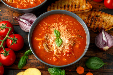 Seasonal vegetables classic minestrone soup with pasta served with cheese, grilled sour dough bread and basil leaves