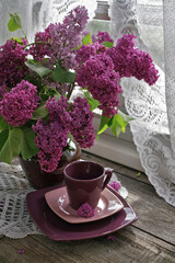 Cup with lilac on window 