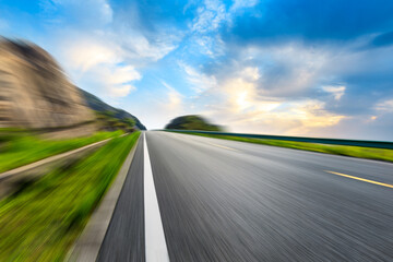 Motion blurred asphalt road and mountain natural landscape on a sunny day.