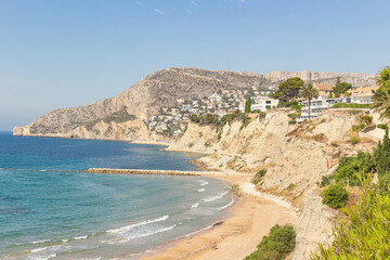 Fototapeta na wymiar Deserted beach of Calpe, Spain, in the background of mountains and houses
