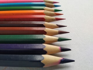 color pencils arranged from dark shades to light shades with white background