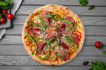Tasty hot italian pizza with prosciutto and arugula. Pizzeria menu. Concept poster for Restaurants or pizzerias. Top view