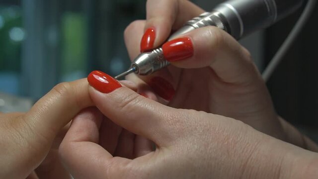 Hardware manicure. Removal of old gel. Manicurist woman removes gel shellac polish from client's nails using manicure machine