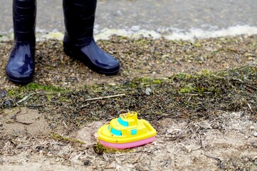on the shore rubber boots and a children's toy