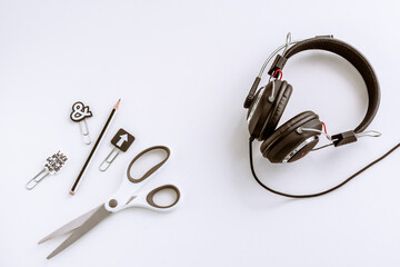 black and white stationery. scissors, paper clips, and black headphones