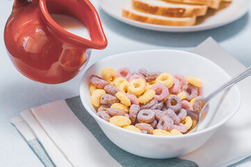 multi-colored cereal rings in a white plate and red milkman