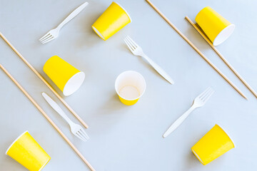 Eco-friendly disposable tableware on a gray background. Paper cups, biodegradable Cutlery, wooden...