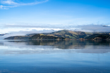 Silhouette of mountains in the misty morning. View of the mountains in early winter. Beautiful nature landscape. Bank Peninsula, Robinsons bay, Canterbury, Ndw Zealand.