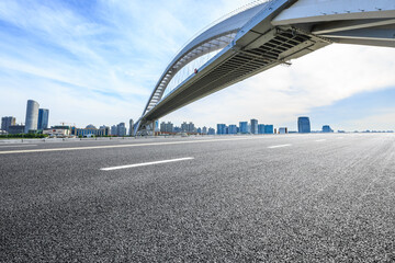 Empty asphalt road and city skyline with bridge construction in Shanghai,China.