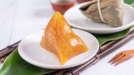 Zongzi - Alkaline rice dumpling - Traditional sweet Chinese crystal food on a plate to eat for Dragon Boat Duanwu Festival celebration concept, close up.