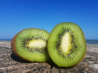 Halved kiwi on a wooden surface.