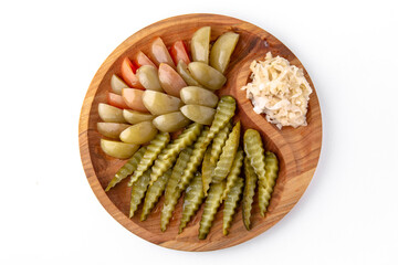 Pickles in a wooden plate. Banquet festive dishes. Gourmet restaurant menu. White background.
