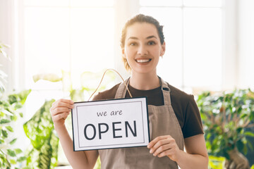 business owner holding the sign for the reopening