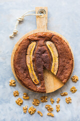 View of a homemade round banana bread with bananas and walnuts.
