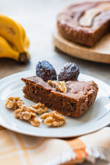 View of a homemade round banana bread with bananas, dates and walnuts.