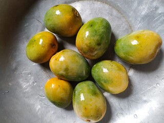 Green and yellow mangoge natural food on a wooden table 