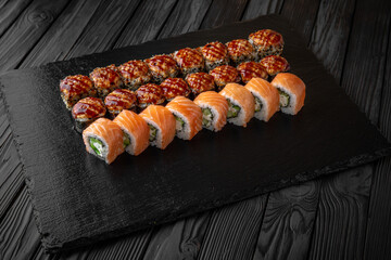 Sushi set. Philadelphia roll, california, unagi, black dragon with fresh ingredients on black background. Sushi menu. Japanese food. 