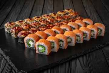 Sushi set. Philadelphia roll, california, unagi, black dragon with fresh ingredients on black background. Sushi menu. Japanese food. 