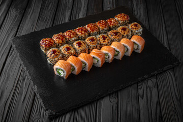 Sushi set. Philadelphia roll, california, unagi, black dragon with fresh ingredients on black background. Sushi menu. Japanese food. 