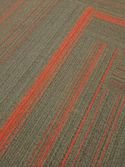 A shot from above of the Unique patterns on the floor mat in a shopping mall. The red and grey combination seems to reveal a striking effect.