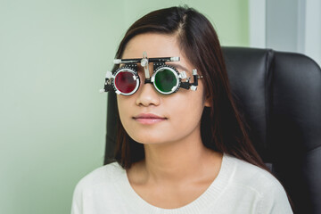 Naklejka premium Consultation with an ophthalmologist. Young asian woman in clinic office.