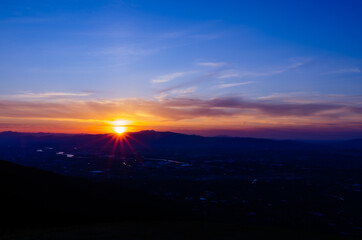 山に沈む夕焼けと河と平野