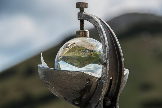 Meteorological heliograph situated in front of Zavizan mountain hut and meteorological station on the Velebit mountain in Croatia. Zavizan kosa is blurred and visible behind it.