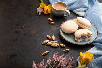 Meringues cakes with cup of coffee on a black concrete background. Side view, copy space.