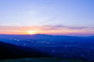 山に沈む夕焼けと河と平野