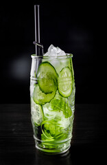 cucumber and mint lemonade in a glass on black wooden table background