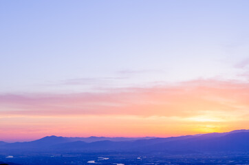 山に沈む夕焼けと河と平野