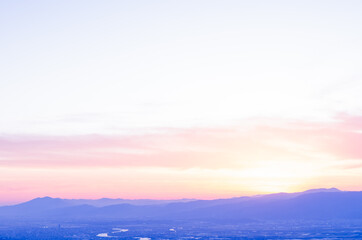 山に沈む夕焼けと河と平野