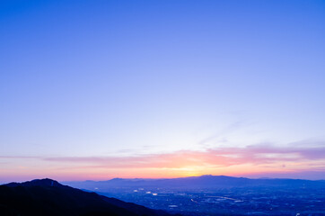山に沈む夕焼けと河と平野