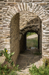 Fototapeta na wymiar Gateway through the wall of a medieval castle ruin.