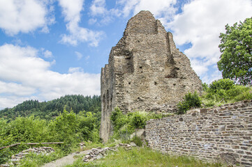 The ruin of the main house of a medieval castle, illuminated by the sun on a slightly cloudy summer...