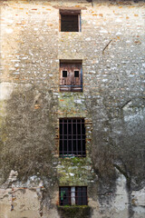 Fototapeta na wymiar Caratteristiche finestre di antico palazzo abbandonato in città, borgo medievale di Strassoldo. 