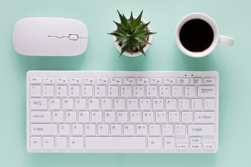 office workplace, computer keyboard with coffee cup, evenly arranged objects, bright colors, top view