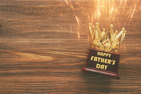 Father's day concept with crown trophy over wooden background. top view, flat lay