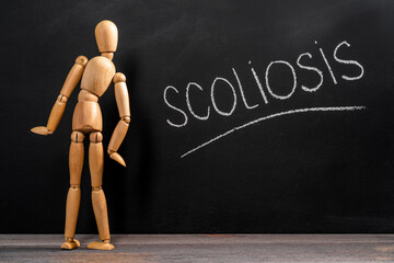 Back pain concept. wooden toy man with scoliosis.