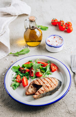 Grilled Pink salmon steak and salad on concrete background. Healthy food concept. Top view