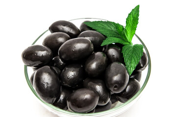 Black olives with mint leaves on a white background