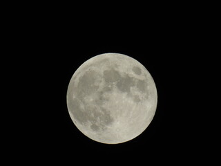 An amazing photography of the full moon over the city of Genova by night with a great clear sky in background and some stars