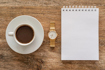 Obraz na płótnie Canvas Coffee break concept with cup of coffee, blank notebook paper on wooden background.