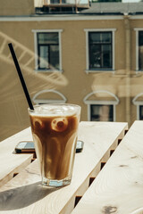 
iced coffee on a wooden table by the window