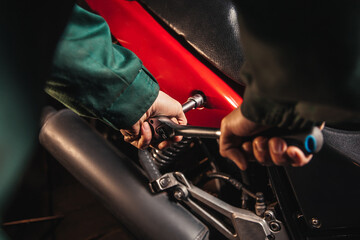 Close-up male hands with wrenches. Auto mechanic works in the garage. Repair service. Motorcycle repair. 