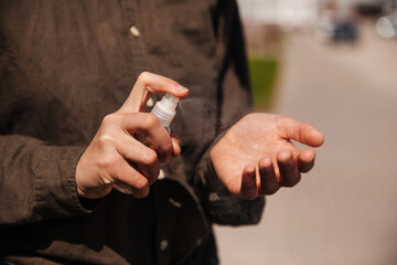 Man sprays a disinfectant on his hands