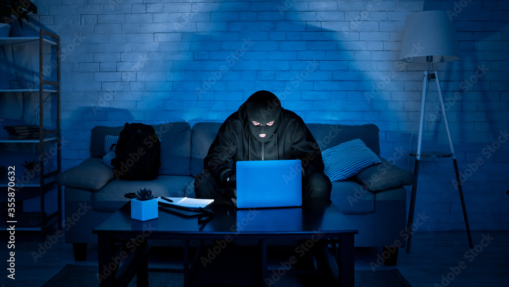 Poster Masked hacker downloading private information using laptop