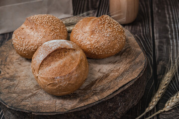 rustic crusty loaves of delicious fresh bakery bread and buns on cutting board.on a wooden table. top view. flat lay.