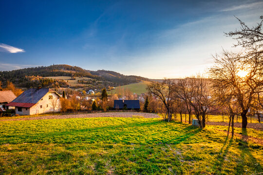 Rural landscape at sunset. Country houses with gardens in a village in the Kysuce region of northwestern Slovakia, Europe.