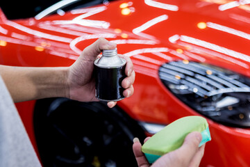 Car service worker applying nano coating on a car detail
